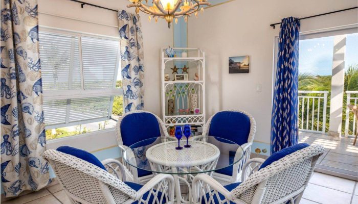 Coastal dining room with wicker furniture.