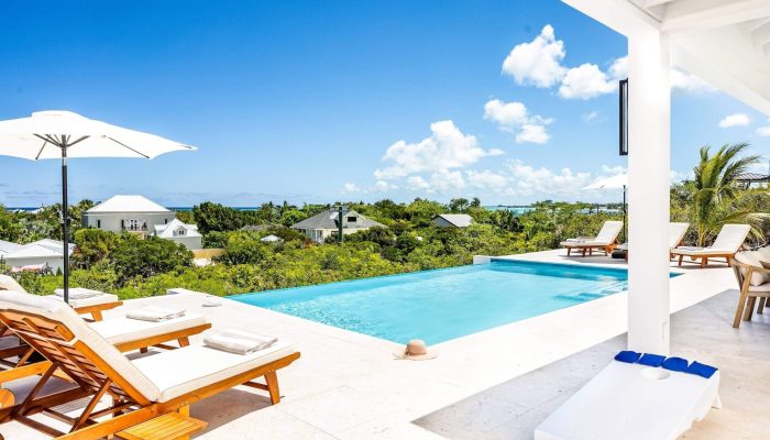 Luxurious poolside view with lounge chairs.
