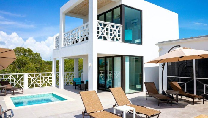 Modern villa with pool and sun loungers.