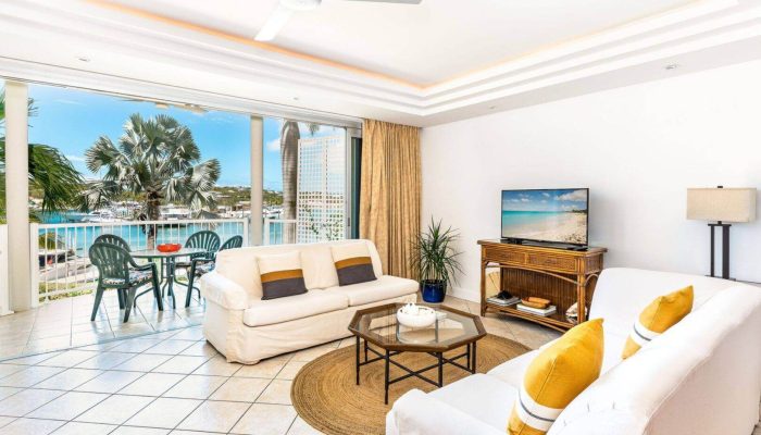 Sunlit beachfront condo living room with balcony