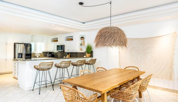 Modern kitchen and dining area with rattan chairs.