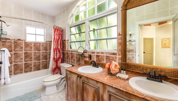 Bathroom with double sinks and large mirror.