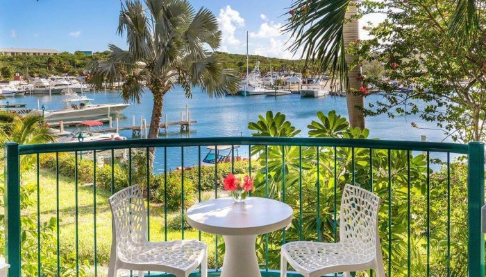 Balcony overlooking marina with table and chairs.