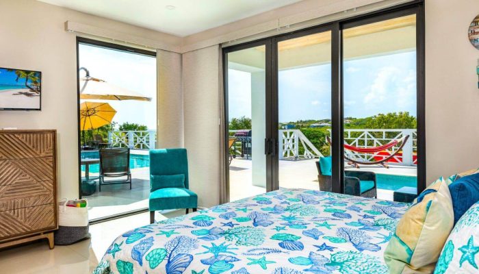 Bedroom with poolside view and hammock.