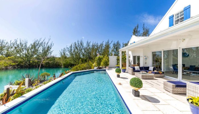 Modern house with pool and blue sky.
