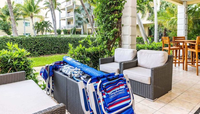 Patio furniture with beach chairs and greenery.