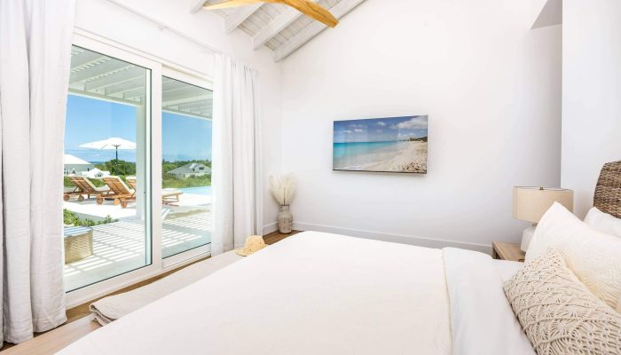 Bright coastal bedroom with outdoor view.