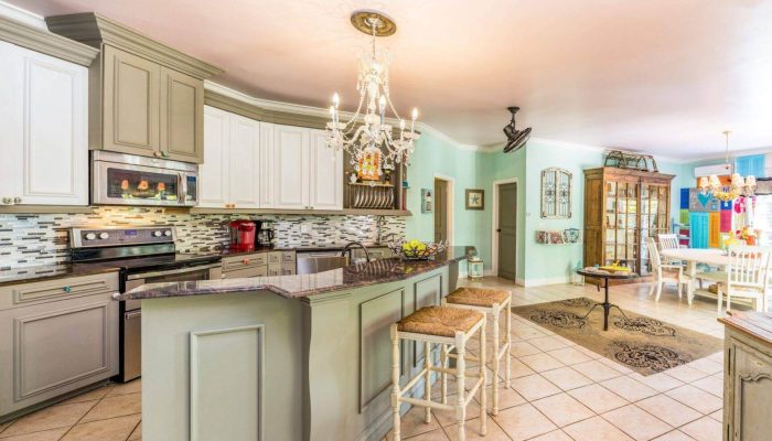 Spacious kitchen with chandelier and seating area.