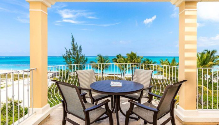 Balcony view with ocean and chairs.
