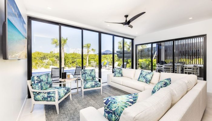 Sunlit living room with sectional sofa, tropical cushions