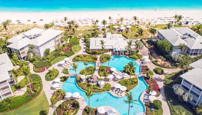 Aerial view of tropical resort with pool.
