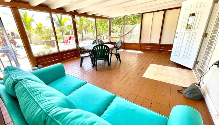 Screened porch with teal sofa and chairs.