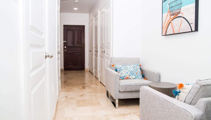 Bright hallway with two grey chairs.