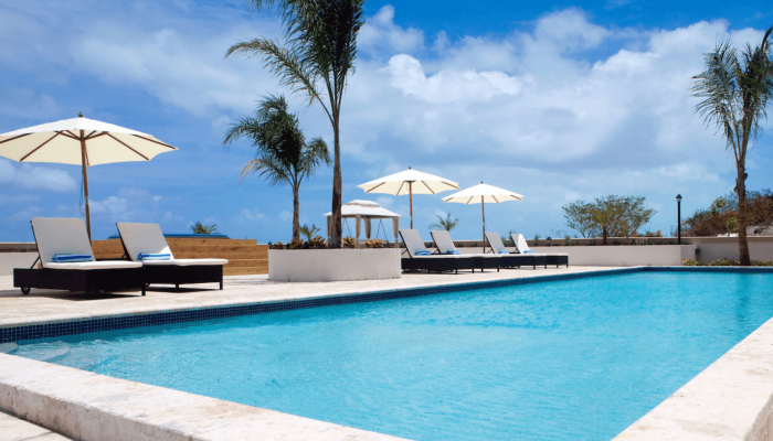 Outdoor pool with loungers and umbrellas.