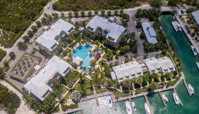 Aerial view of waterfront resort with pool.