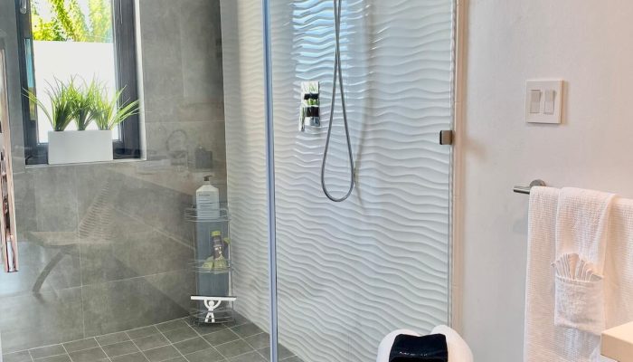 Modern bathroom with glass shower and rolled towels