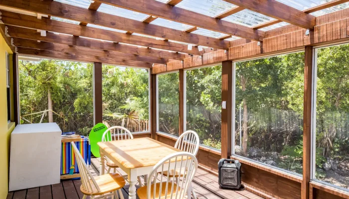Enclosed patio with table and chairs.