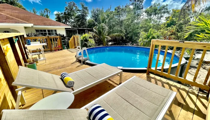 Poolside deck with loungers and towels.